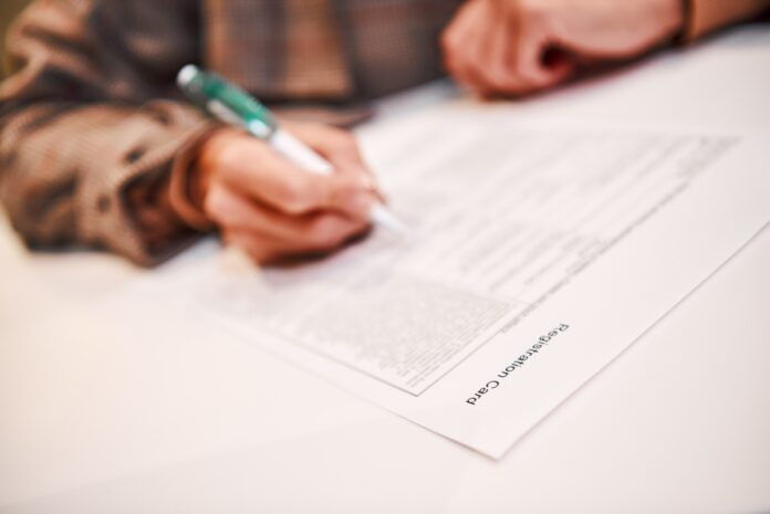 Optimized-businesswoman-is-fulfilling-and-signing-contract-w-2021-11-03-18-18-22-utc